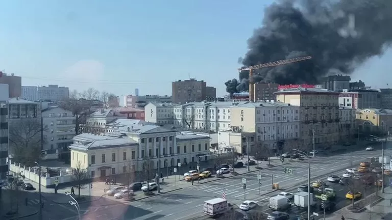 Машины скорой помощи едут к горящему зданию в центре Москвы